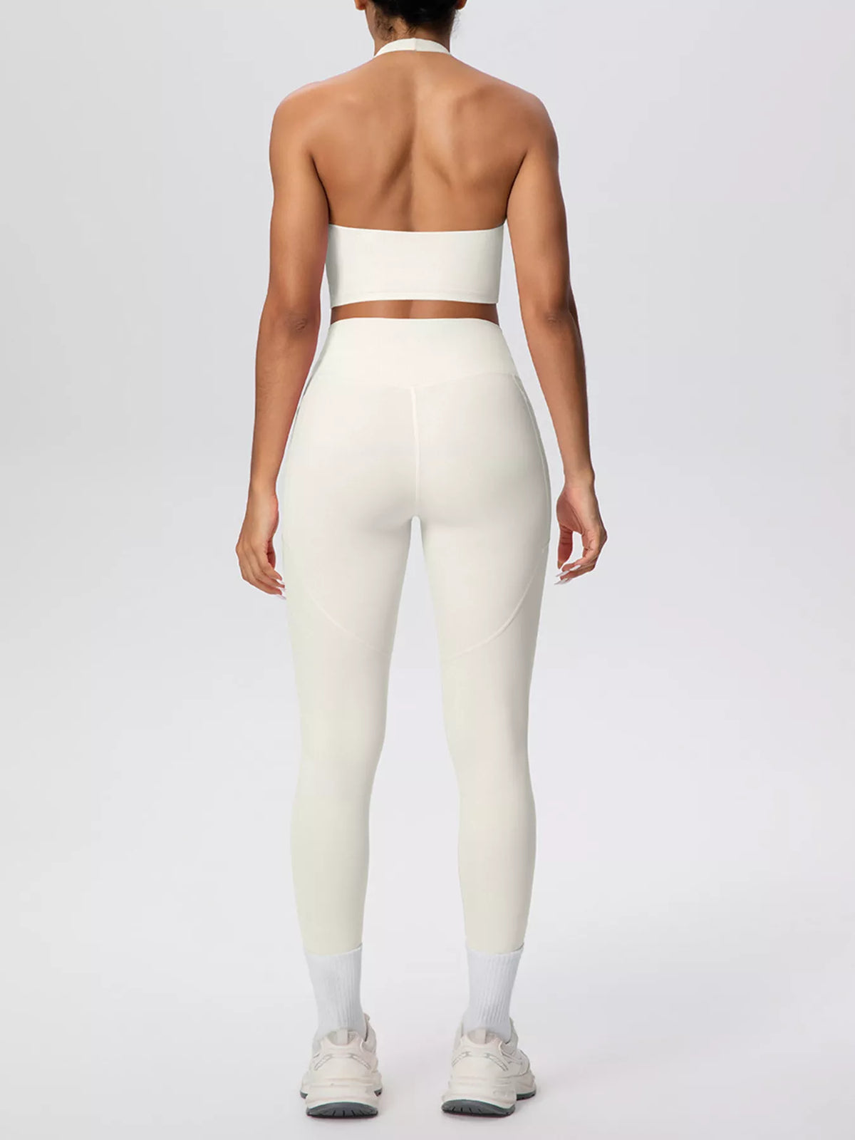 Rear view of white halter top with leggings and curved side seams