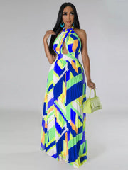 Front view of a blue and lime geometric halter dress on a model carrying a light green handbag.