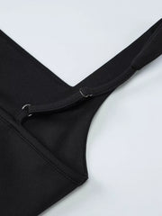 Close-up of the black dress's side slit and ruched fabric.