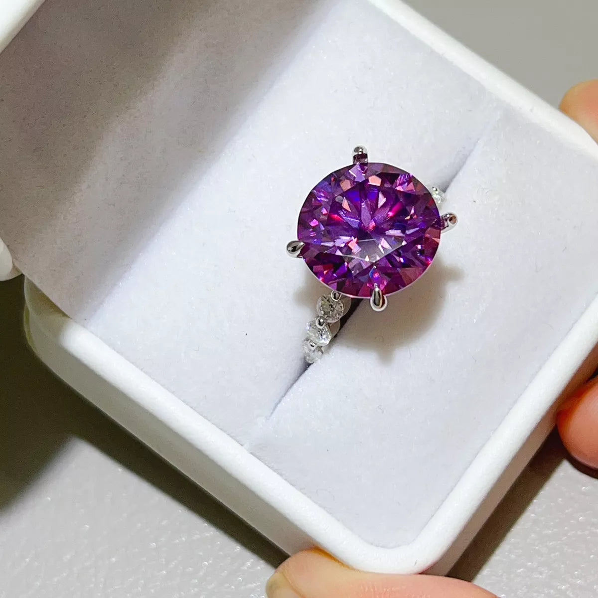 Purple centre-stone ring viewed from above inside its box