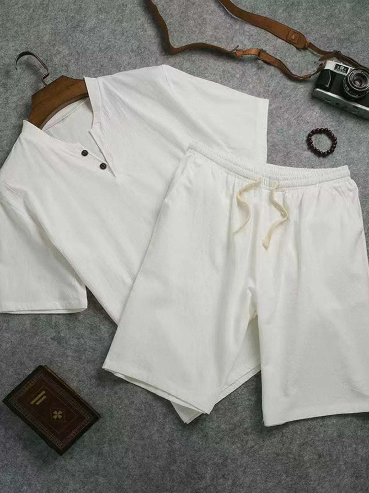 White short-sleeve two-button shirt and matching drawstring shorts laid flat