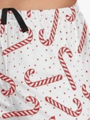 Close-up of red candy cane and dotted print beside the black drawstring on white shorts