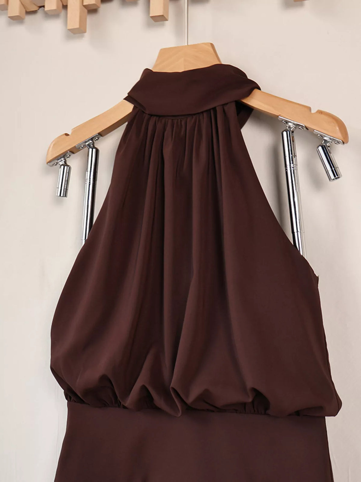 Close view of gathered high neckline and draped bodice of dark brown dress