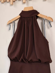Close view of gathered high neckline and draped bodice of dark brown dress