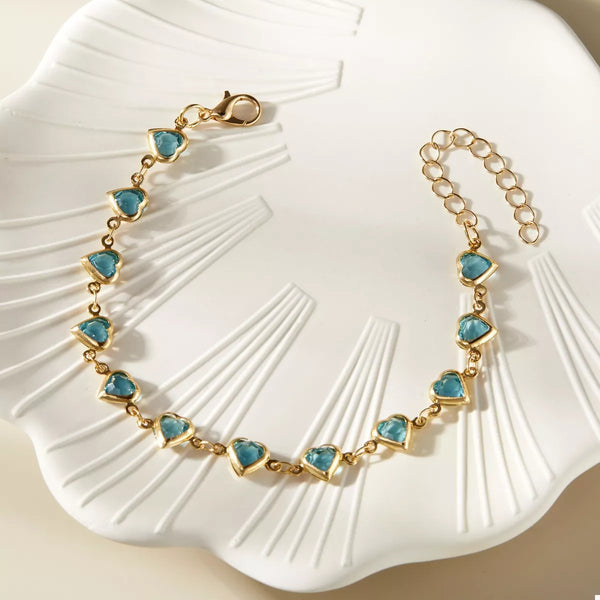 Gold-tone heart bracelet worn on wrist