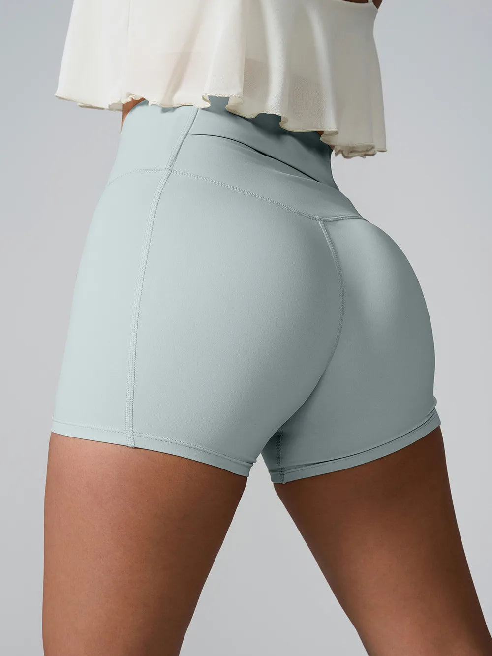 Angled back view of pale blue high-waist active shorts.