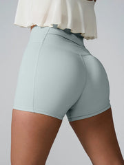 Angled back view of pale blue high-waist active shorts.