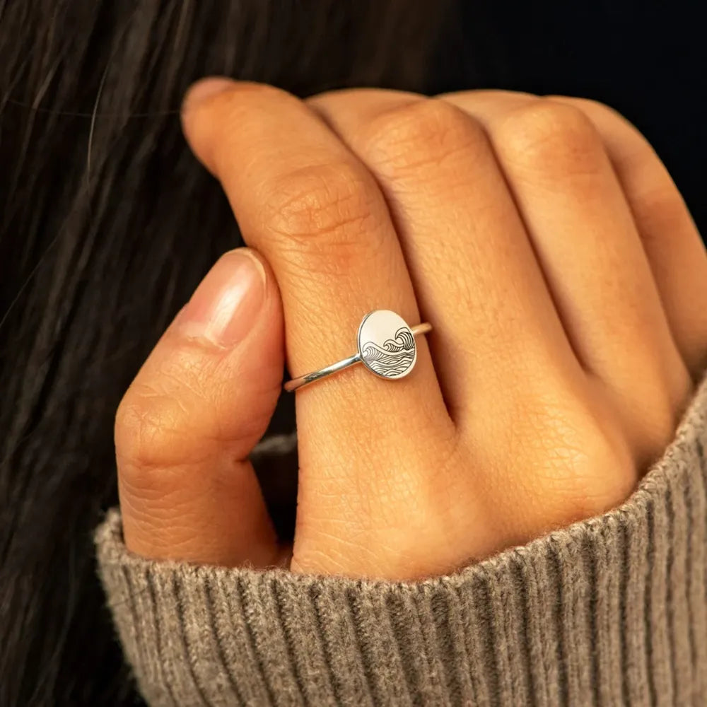 Engraved round face ring worn on hand