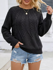 Front view of a black cable-knit sweater with distressed denim shorts