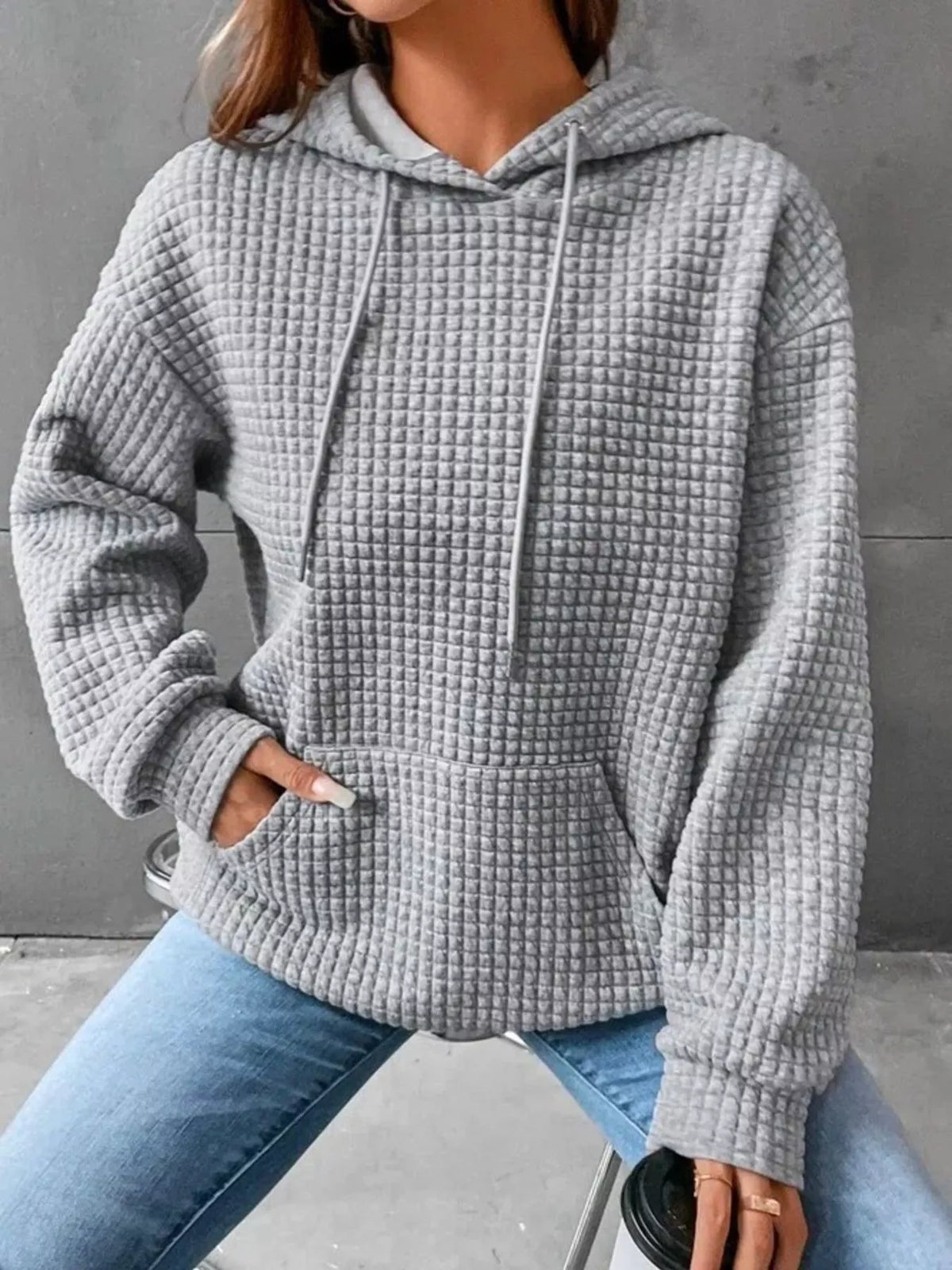 Front view of grey textured hoodie with drawstring hood and kangaroo pocket