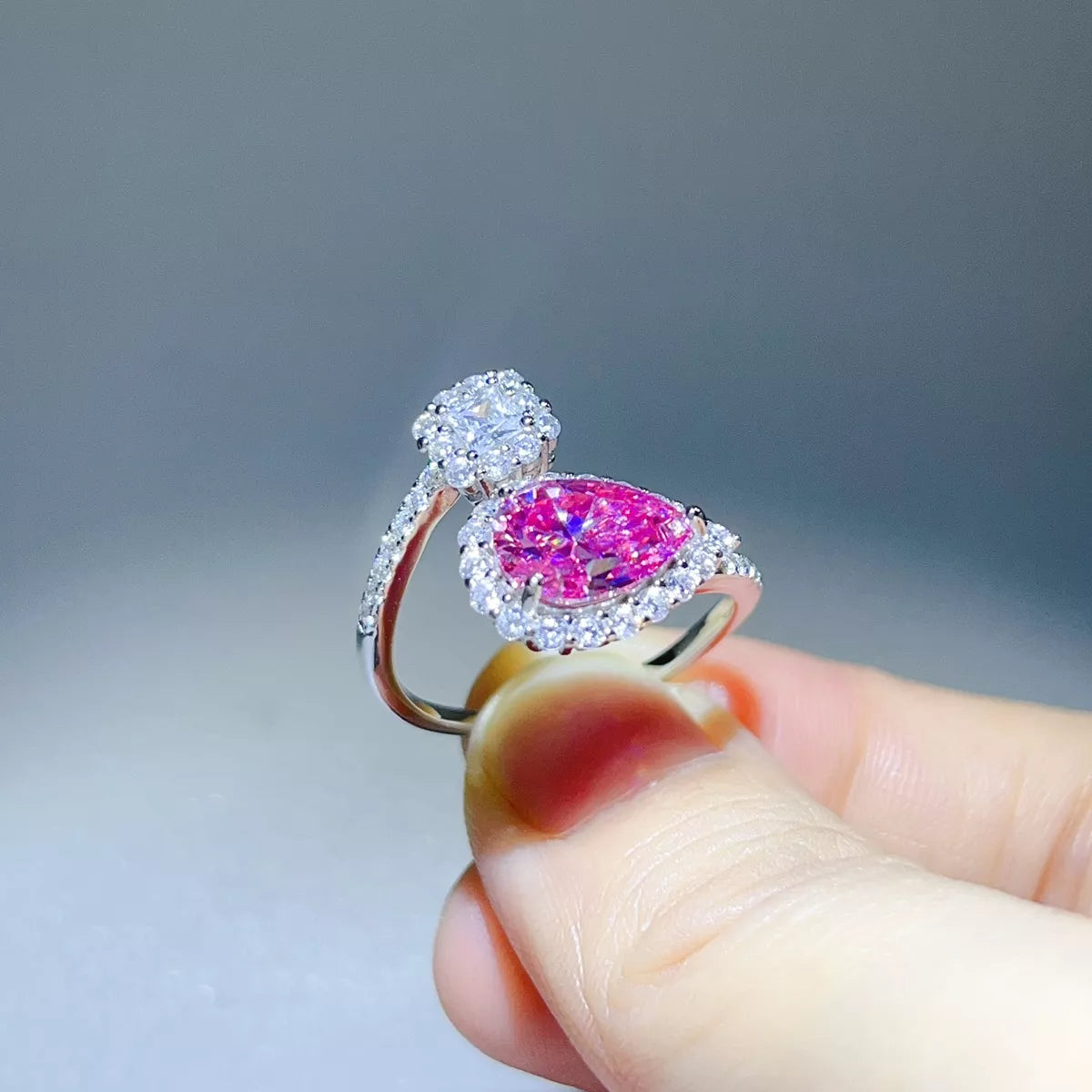 Side profile of pink pear-shaped bypass ring showing raised setting