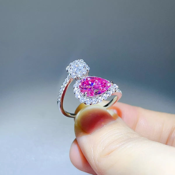 Side profile of pink pear-shaped bypass ring showing raised setting
