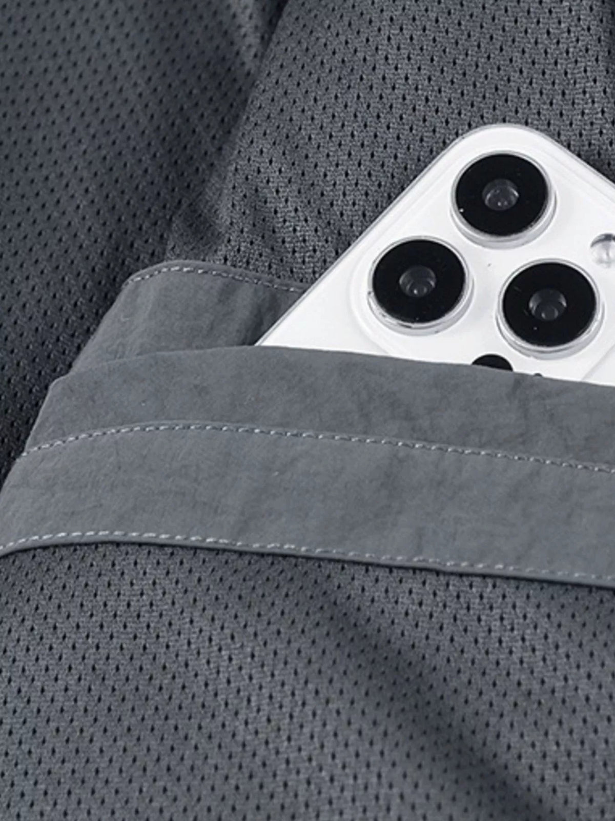 Close-up of jacket's mesh lining and internal pocket holding a mobile phone