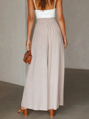 Model wearing navy wide-leg pants with a shoulder bag