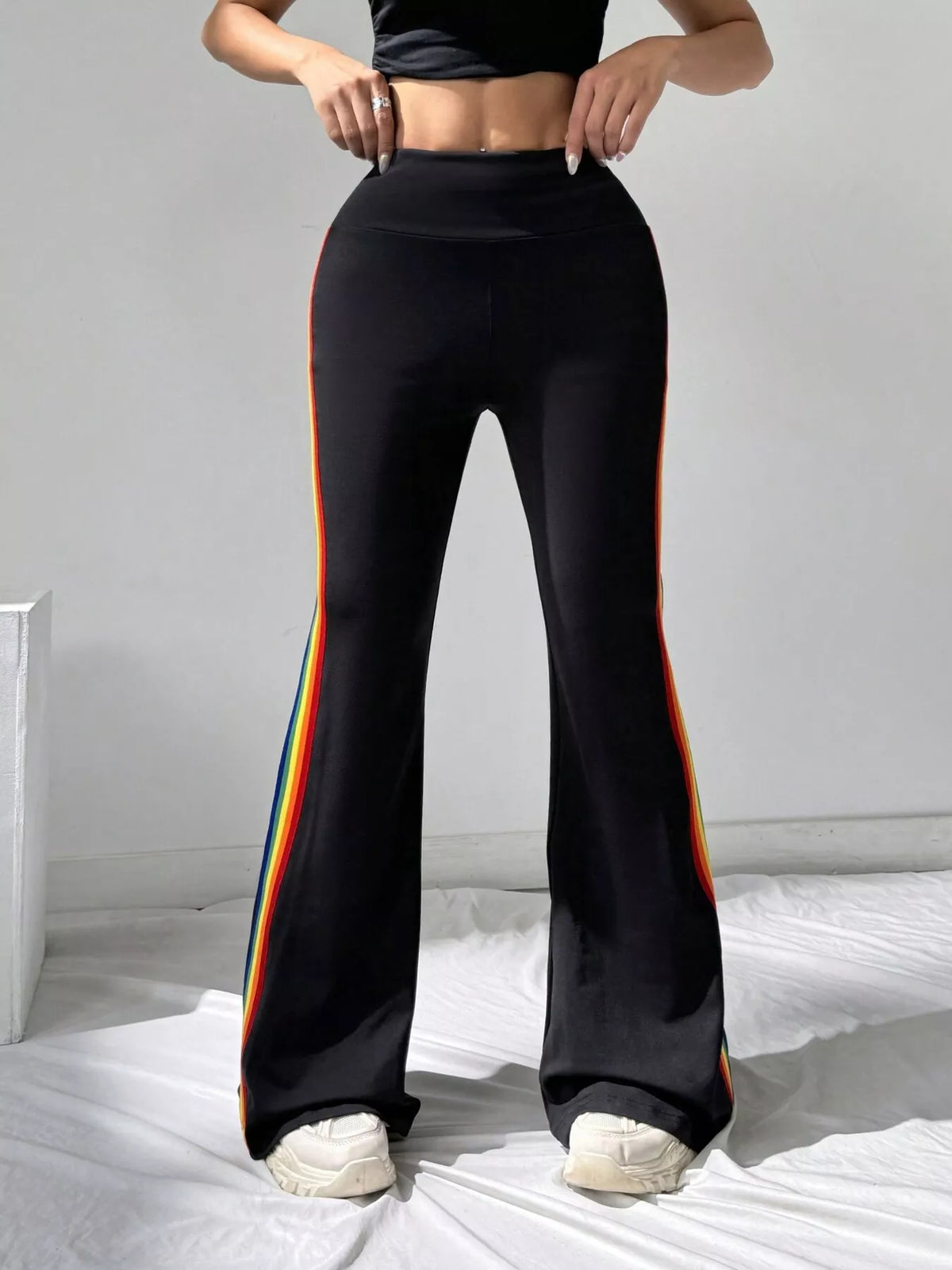 Black high-waisted flare pants with rainbow side stripes