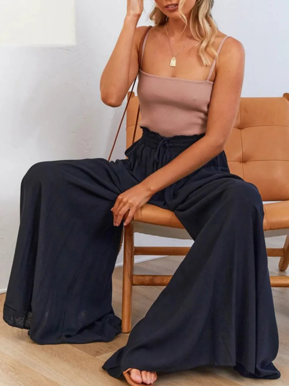 Model standing in navy wide-leg pants and white crop top