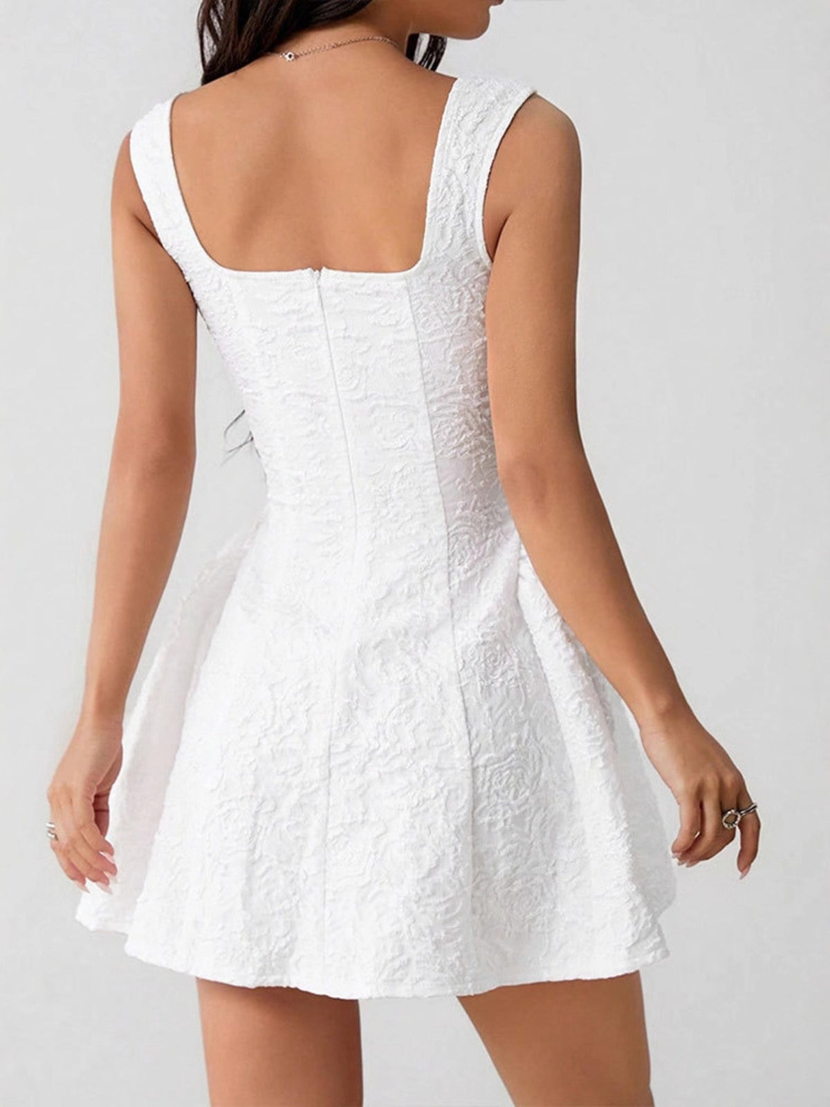 Back view of white mini dress with square back and zipper