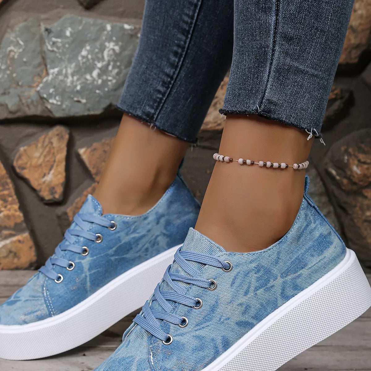 Blue sneakers worn with jeans, side view