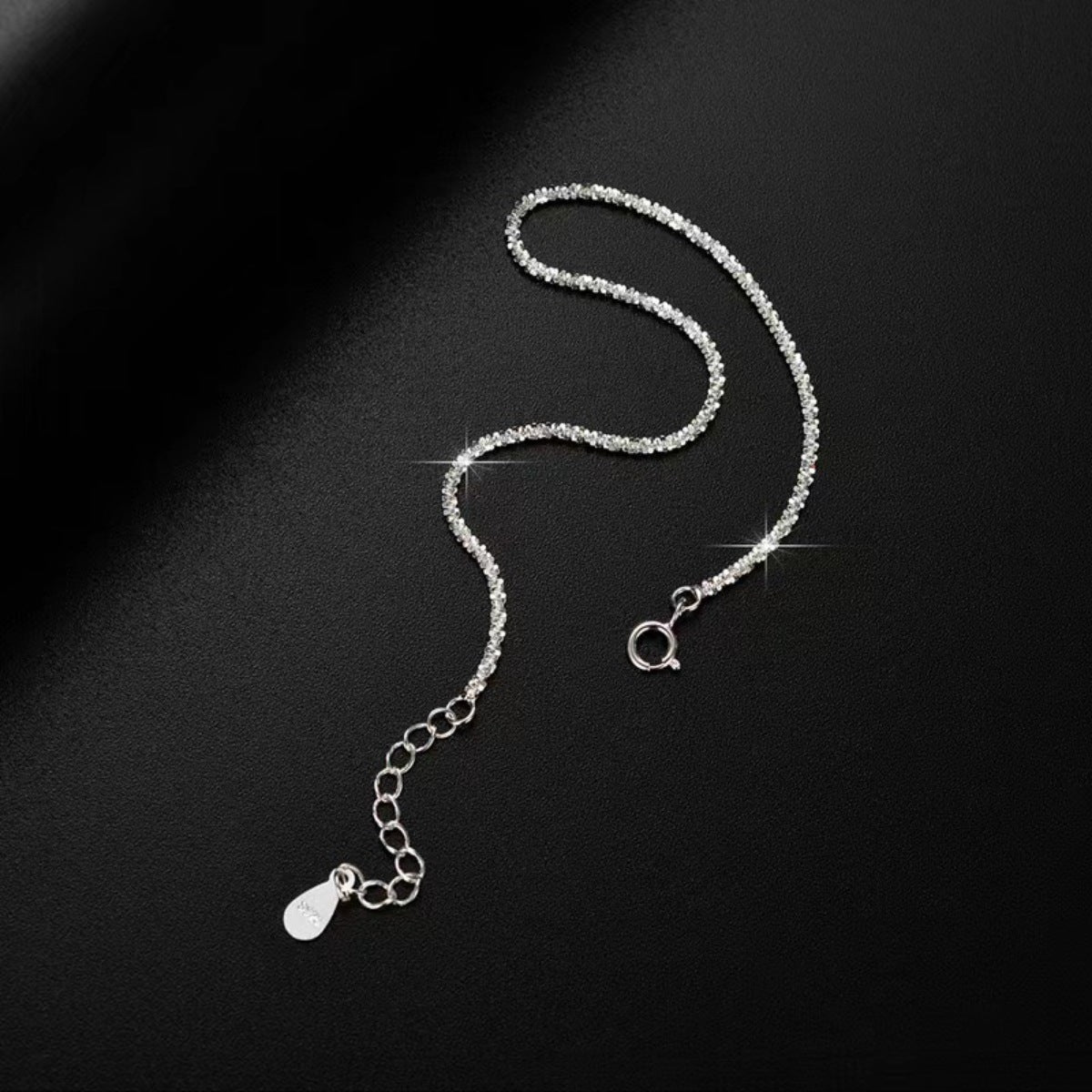Close-up of the silver bracelet's fine chain and adjustable end