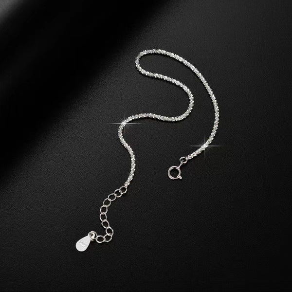 Close-up of the silver bracelet's fine chain and adjustable end