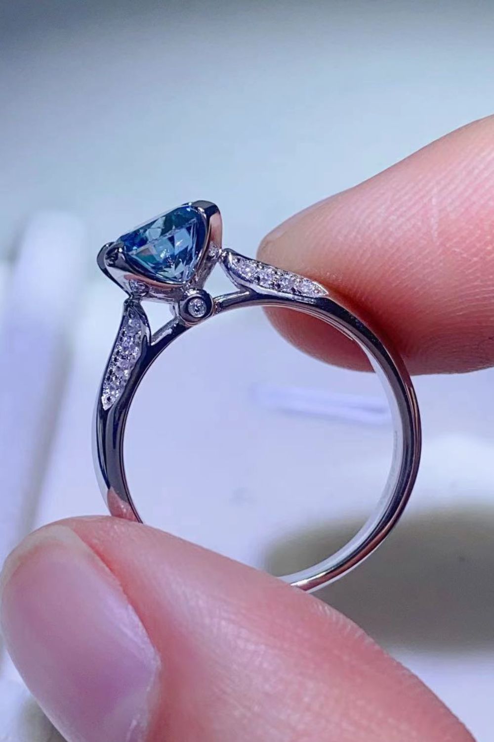 Sky-blue moissanite solitaire ring displayed at an angle