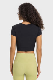 Back view of black cropped T-shirt paired with pale yellow leggings