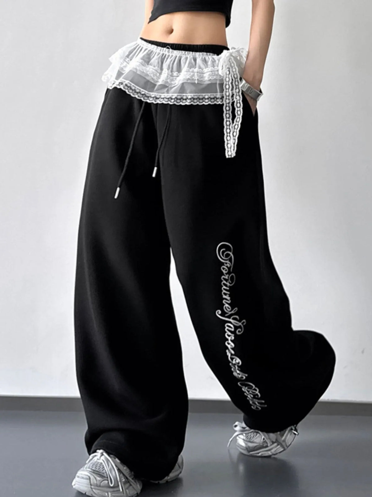 Black wide-leg drawstring pants with lace overlay and script print