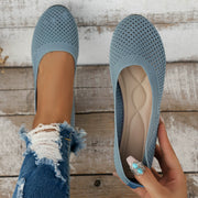 Light blue mesh flats held overhead with insoles visible