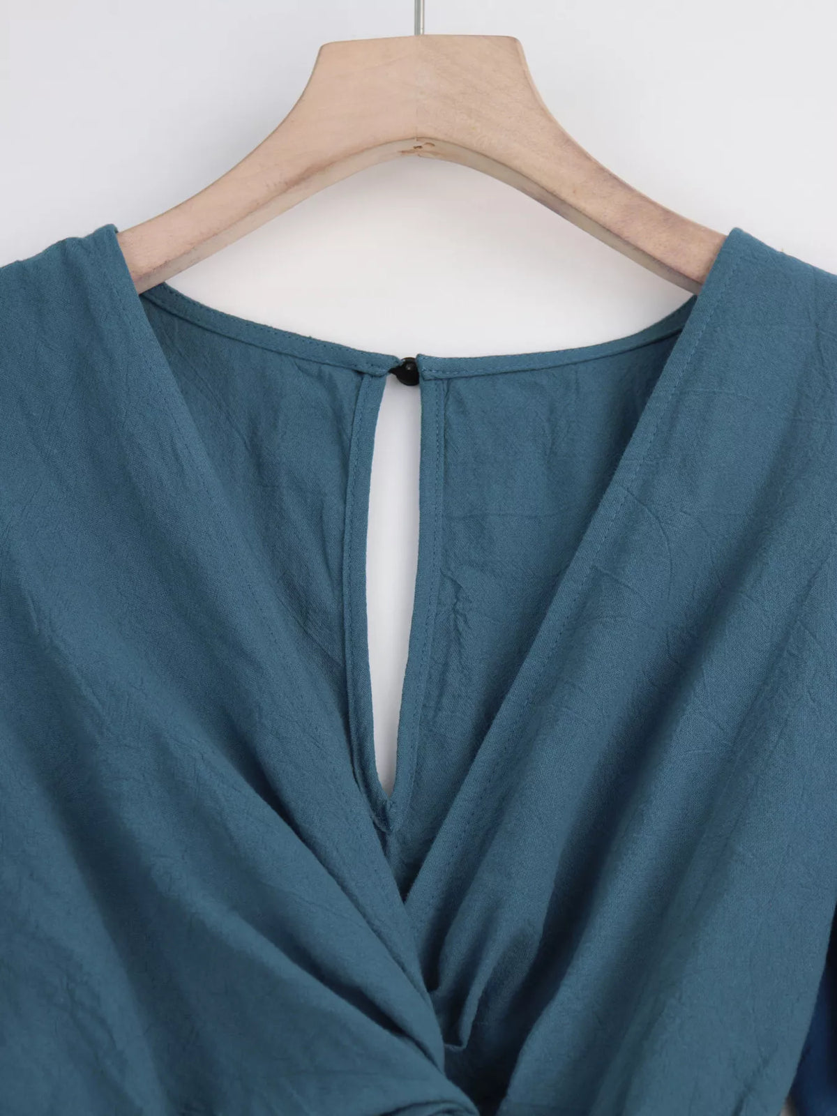 Close-up of haze blue back neckline and button