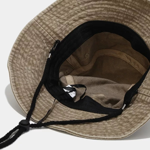 Inside view of khaki bucket hat showing the crown lining and chin cord