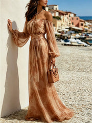 Front angled view of the brown maxi dress with one arm raised against a wall