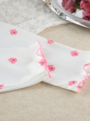 Close-up of scalloped pink trim on white floral-print sleeve cuff