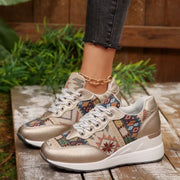 Angled view of cream patterned sneakers with metallic champagne toe accents