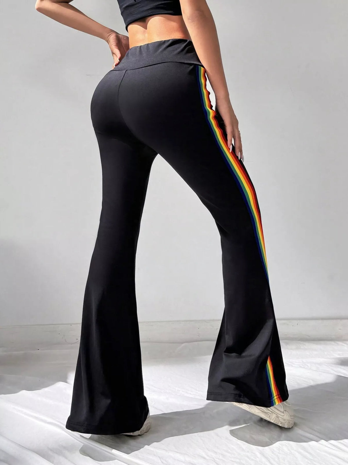 Rear view of black flare pants with rainbow side stripe