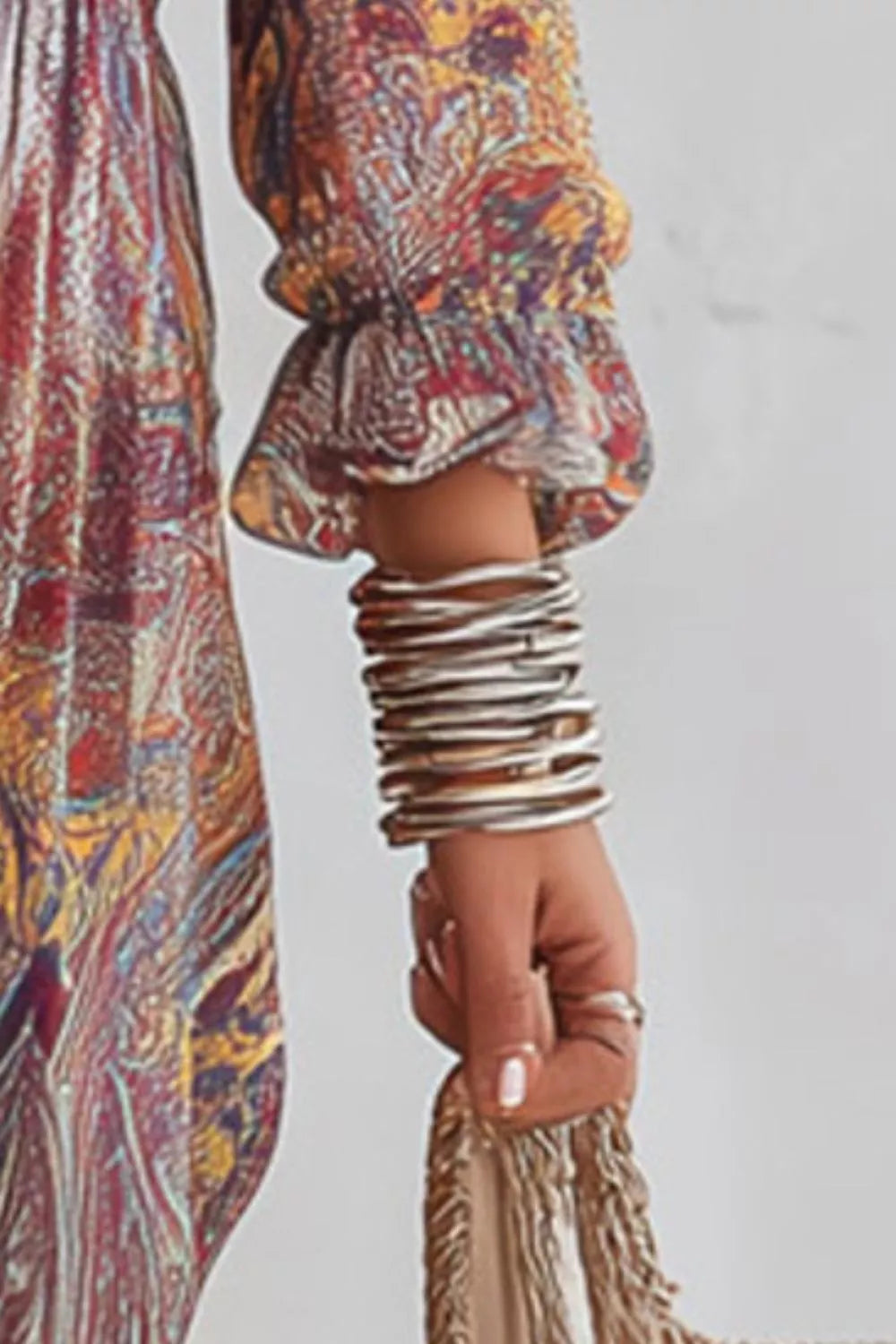 Detail of the paisley dress's gathered sleeve cuff, shown beside a woven bag.