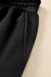 Close-up of black jogger fabric, elastic waistband, and pocket opening
