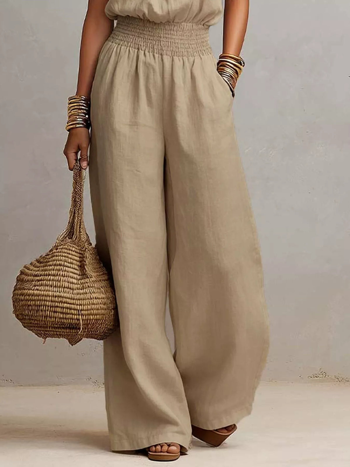 Model showing the wide-leg fit and side pockets of the beige jumpsuit