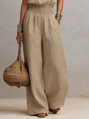 Model showing the wide-leg fit and side pockets of the beige jumpsuit