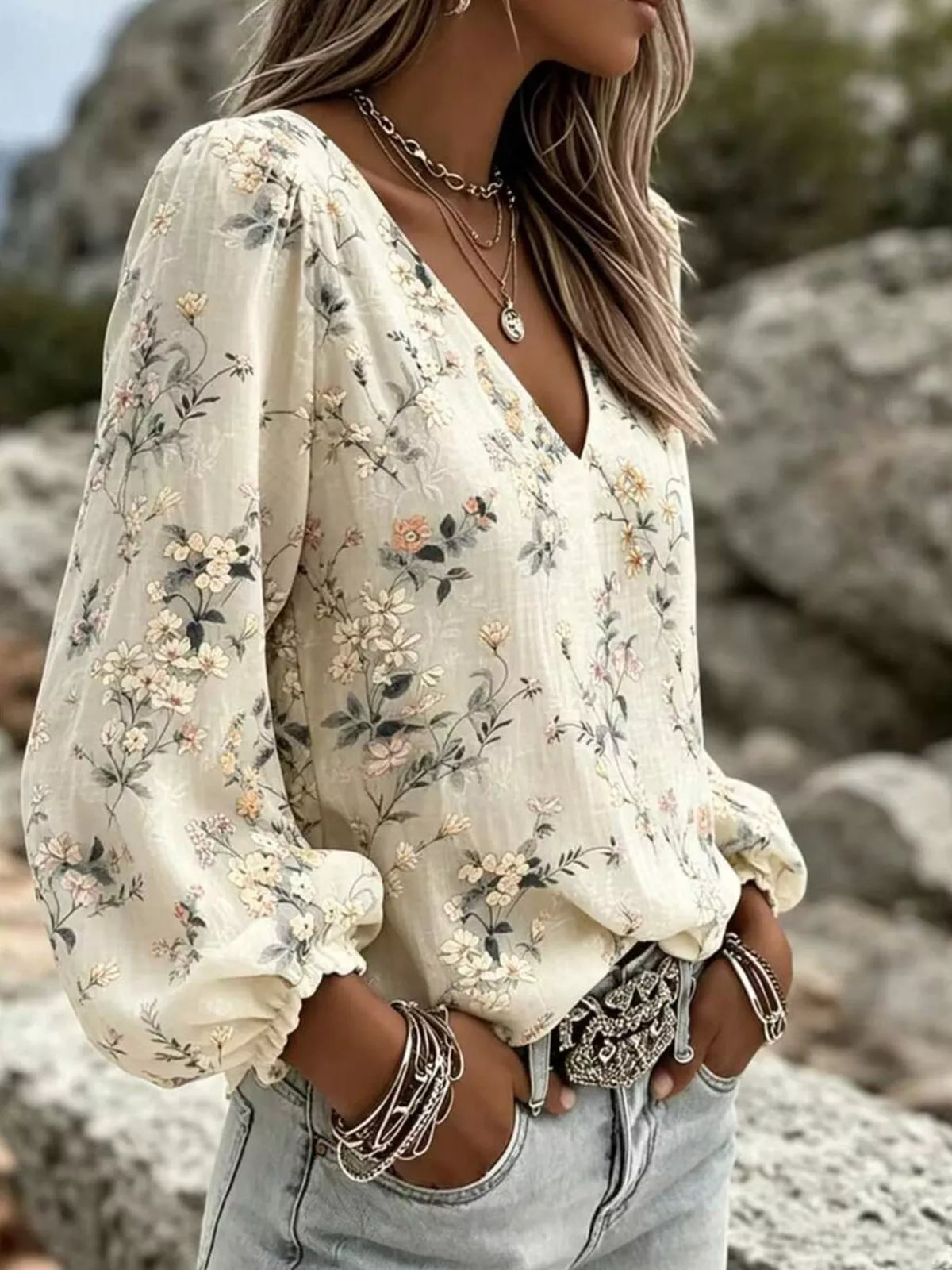 Side view of cream floral V-neck blouse with long gathered sleeves