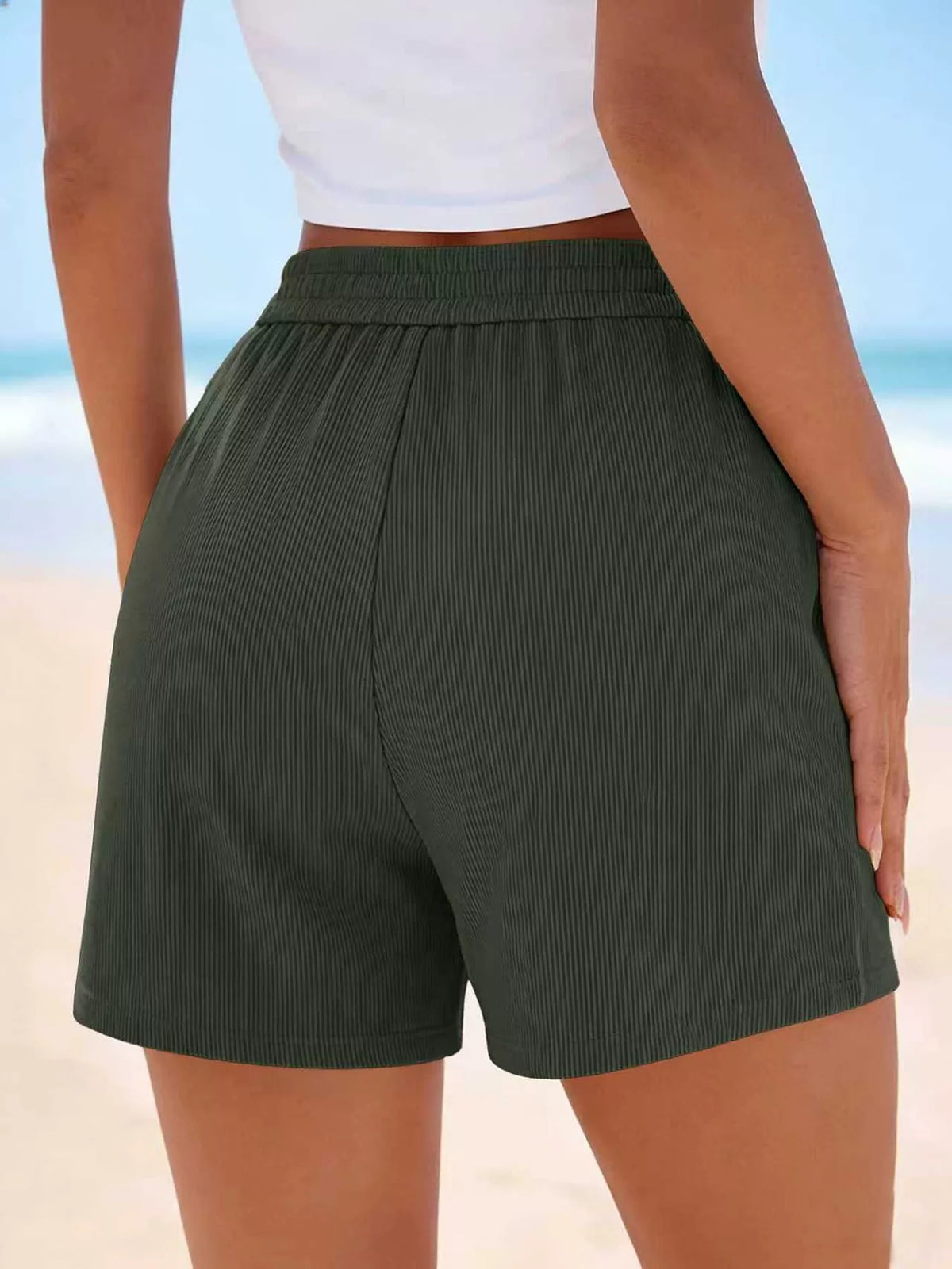 Back view of dark green shorts showing the gathered waistband