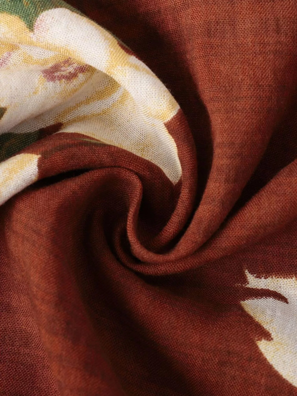 Close-up of cream flower print on rust-brown fabric