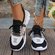 Pair of black and white mesh sneakers with tan patterned panels, top view