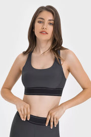 Model wearing a charcoal contrast sports bra with a wide black band, front view