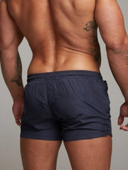 Model wearing navy drawstring active shorts, back view