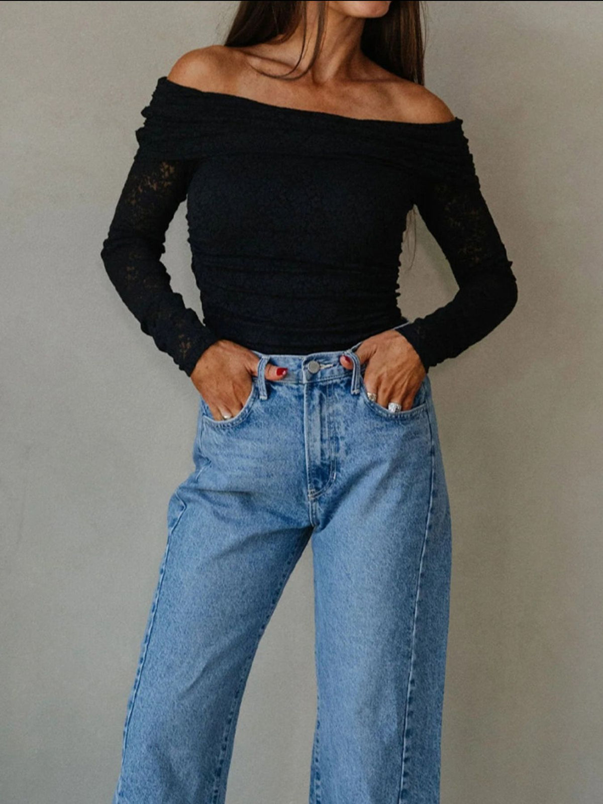 Full outfit view of black off-shoulder top with jeans