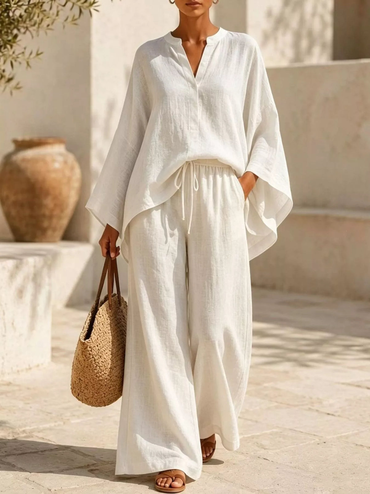 Woman wearing the ivory set with a notched top and wide-leg pants, full-length view.
