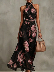 Model wearing a black floral sleeveless tiered maxi dress with a high neckline.