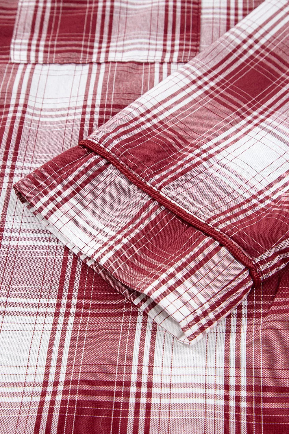 Close-up of red plaid shirt cuff and sleeve trim