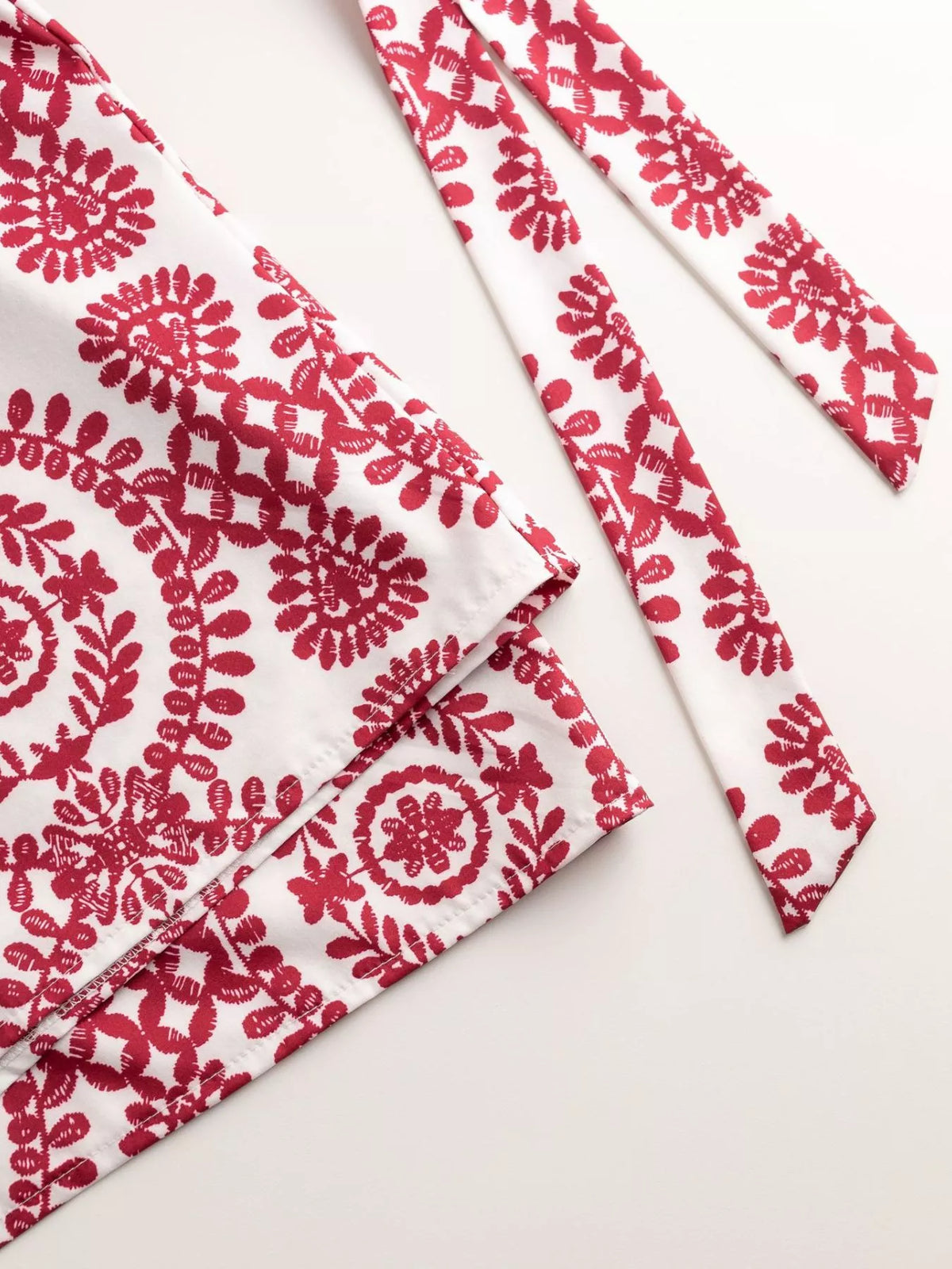 Women's printed tie-waist button-front romper, close-up of red printed belt