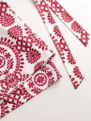 Women's printed tie-waist button-front romper, close-up of red printed belt